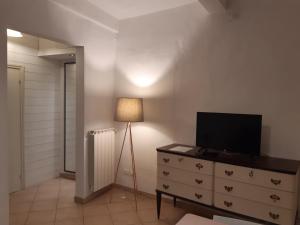 Cette chambre comprend une commode avec une télévision et une lampe. dans l'établissement casa de blu, à Florence