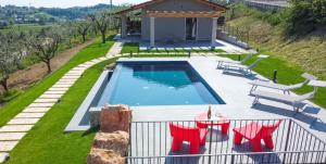 una piscina con sillas y una casa en Villa Boni, en Costermano