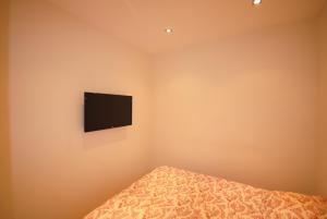 a bedroom with a bed and a tv on the wall at Résidence Gray d'Albion 2P NAP558 in Cannes