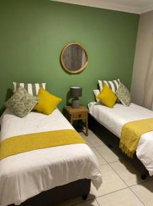 Zimmer mit 2 Betten und einem Wandspiegel in der Unterkunft Gable Cottages No.4 Clarens in Clarens