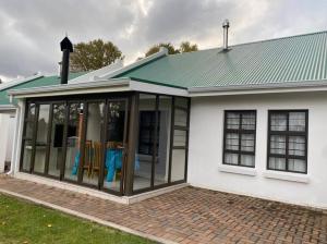 eine abgeschirmte Veranda auf einem Haus in der Unterkunft Gable Cottages No.4 Clarens in Clarens