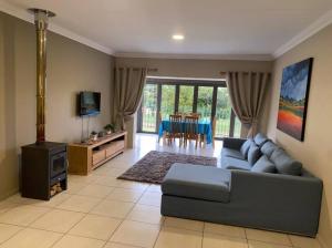 a living room with a couch and a tv at Gable Cottages No.4 Clarens in Clarens