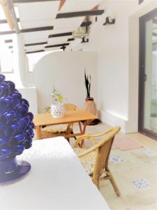 una sala da pranzo con un vaso blu su un tavolo di Dimora d'Estate (Sicilian Holidays) a Milazzo