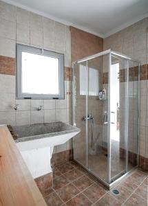 uma casa de banho com um chuveiro, um lavatório e uma cabina de duche. em Casa Elafonisi N1 em Plokamianá