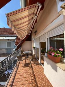 eine Terrasse mit einem Tisch und einem Sonnenschirm in der Unterkunft Luca Apartman in Harkány