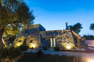 カルピニャーノ・サレンティーノにあるMasseria Azzurro Felicità m595の夜間照明付きの石造りの建物