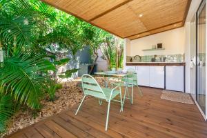 an outdoor patio with a table and chairs at Idylle - Charmant bungalow à 2 pas du lagon in La Saline les Bains