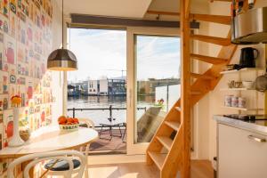 a kitchen with a table and a large window at Houseboat studio with canalview and free bikes in Amsterdam