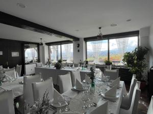 a dining room with white tables and white chairs at Pensiunea Casa Boiereasca in Peştera +52 photos