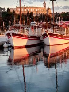 two boats are docked in a harbor with a building in the background at Pula Center Studio Apartments in Pula