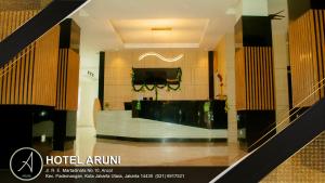 雅加达Hotel Aruni Ancol的一间设有前台和电视的酒店客房