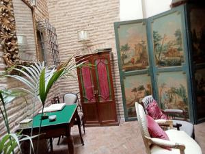 a room with a table and chairs and paintings at Hostal Casa Del Buen Viaje in Seville