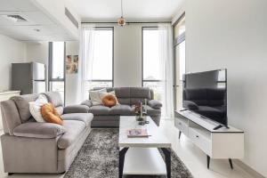 sala de estar con sofá y TV de pantalla plana en Frank Porter - Dania 3 en Dubái