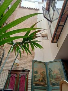 a room with paintings on the wall and a plant at Hostal Casa Del Buen Viaje in Seville
