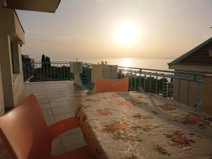 a table and chairs on a balcony with the ocean at Apartments Zolotaya Rybka in Utjeha