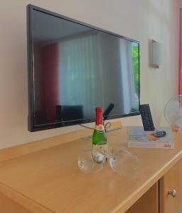 a table with two wine glasses and a television at Hotel Garni Brugger in Lindau