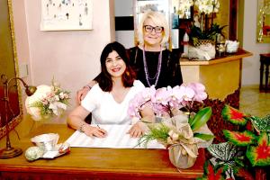 Deux femmes debout à une table avec des fleurs dans l'établissement Villa Zavatta "B&B - Rooms & Apartments", à Bellaria-Igea Marina