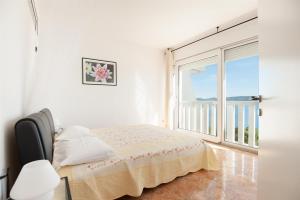a bedroom with a bed and a large window at Apartments Gordana in Lokva Rogoznica