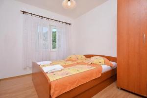 sypialnia z łóżkiem i oknem w obiekcie 2-bedroom apartment with seaview 3558-2 w mieście Žuljana