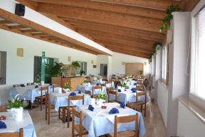 a restaurant with white tables and chairs and wooden ceilings at GARNI ANNA in Besenello
