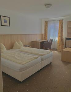 a hotel room with two beds and a table at Hotel Garni Brugger in Lindau