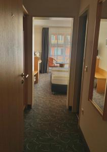 um corredor de um quarto de hotel com um quarto em Hotel Garni Brugger em Lindau
