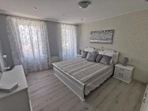 a white bedroom with a bed and two windows at House Green Point in Grižane +26 photos