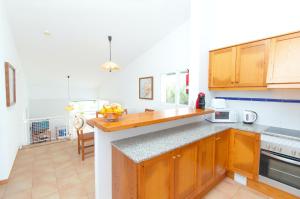 a kitchen with wooden cabinets and a counter top at Villa Belinda by Sonne Villas in Es Migjorn Gran