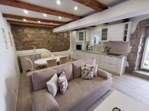 a living room with a couch and a kitchen at House Green Point in Grižane