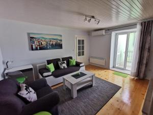 a living room with a couch and a table at House Green Point in Grižane