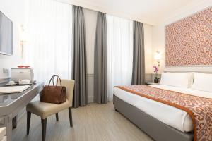 a hotel room with a bed and a desk at Hotel Della Conciliazione in Rome