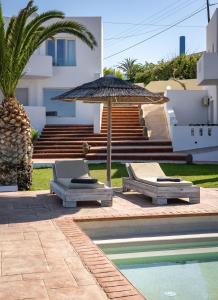 two lounge chairs and an umbrella next to a swimming pool at Arkasa Palace in Arkasa