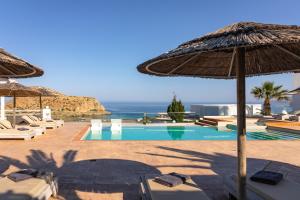 a resort with a swimming pool and an umbrella at Arkasa Palace in Arkasa