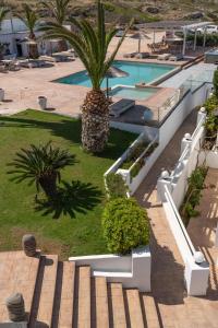 a resort with a palm tree and a swimming pool at Arkasa Palace in Arkasa