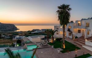 a villa with a view of the ocean at sunset at Arkasa Palace in Arkasa