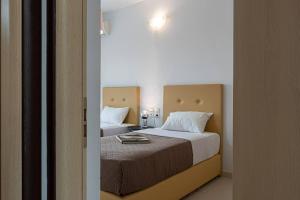 a bedroom with two beds with white pillows at Casa di Brillanti, 2min from the beach! in Karteros