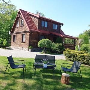 Zabłudów的住宿－Agroturystyka Pasynki 44，一组椅子和一张桌子,位于房子前面