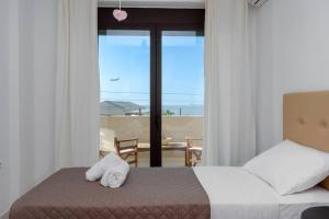 a bedroom with a bed and a view of the ocean at Casa di Brillanti, 2min from the beach! in Karteros