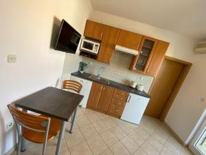 een kleine keuken met een tafel en een magnetron bij Apartment in Punat with Terrace, Air conditioning, Wifi, Washing machine (3829-3) in Punat