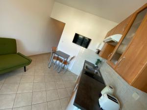 een kleine keuken met een groene bank en een tafel bij Apartment in Punat with Terrace, Air conditioning, Wifi, Washing machine (3829-3) in Punat