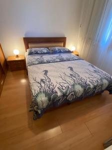 1 dormitorio con 1 cama con edredón azul y blanco en Apartment in Punat with Terrace, Air conditioning, Wifi, Washing machine (3829-3), en Punat