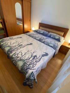 un dormitorio con una cama con un árbol estampado en él en Apartment in Punat with Terrace, Air conditioning, Wifi, Washing machine (3829-3), en Punat