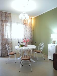 una sala da pranzo con tavolo e sedie bianchi di Portico Cozy Home a Kariá
