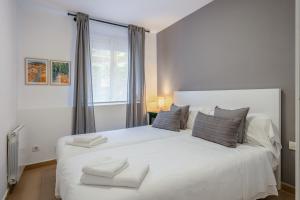 a bedroom with a large white bed with a window at Inside Barcelona Apartments Salva in Barcelona