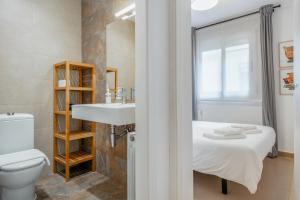 a bathroom with a bed and a sink and a toilet at Inside Barcelona Apartments Salva in Barcelona