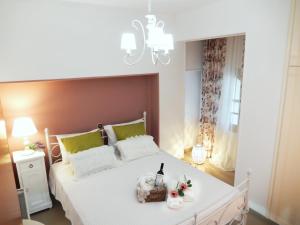 a bedroom with a white bed with a chandelier at Portico Cozy Home in Kariá