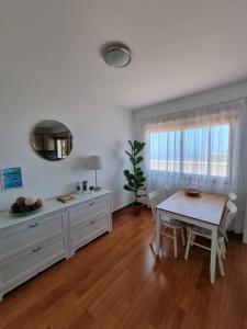Apartamento La Villa في فالفيردي: غرفة معيشة مع طاولة وغرفة طعام