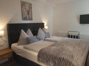 a bedroom with a bed with a black and white comforter at Apartmenthaus WALDHORN in St. Wolfgang