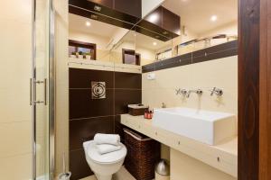 a bathroom with a toilet and a sink at Apartment Butorowy Residence by Renters Prestige in Kościelisko
