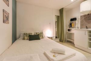 リスボンにあるBairro Alto Blue & Green by Homingのベッドルーム(大きな白いベッド1台付)、キッチンが備わります。